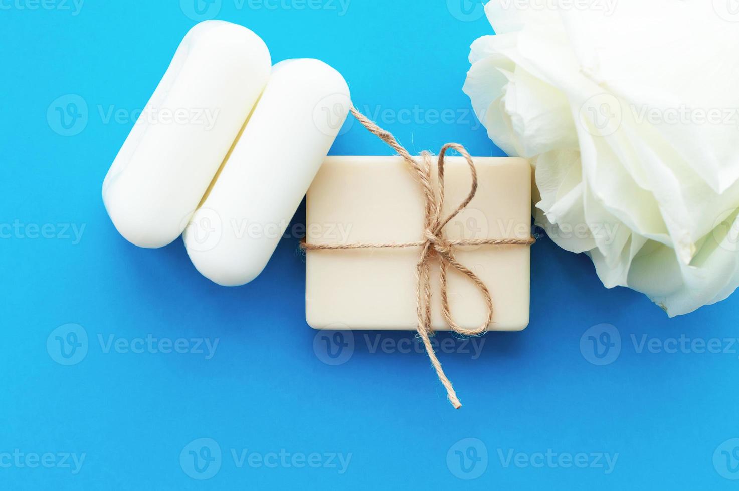 the soap is tied with a rope and a white rose on a blue background with a place for the inscription. Concept of hygiene and Spa procedures. photo