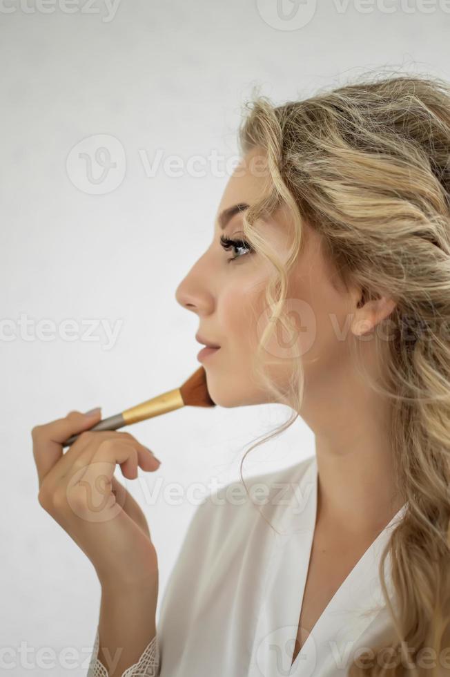 la novia hace el maquillaje de boda el día de la boda antes de la ceremonia. enfoque selectivo. grano de la película. foto