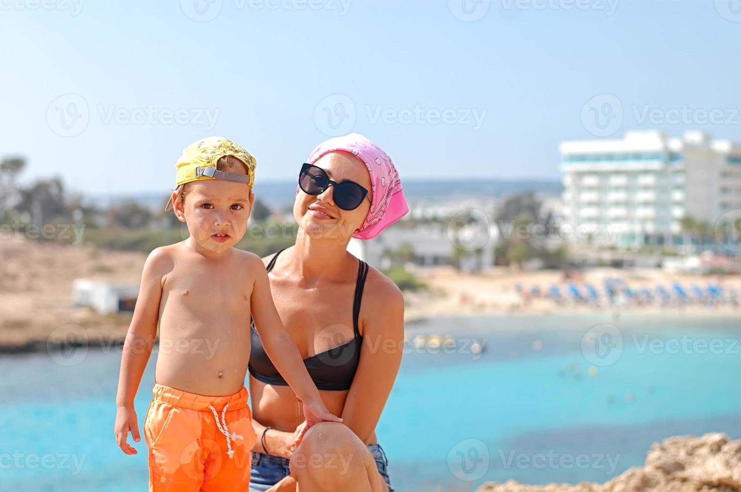 madre e hijo en la playa en un día soleado. turismo, viajes, vacaciones en familia. foto