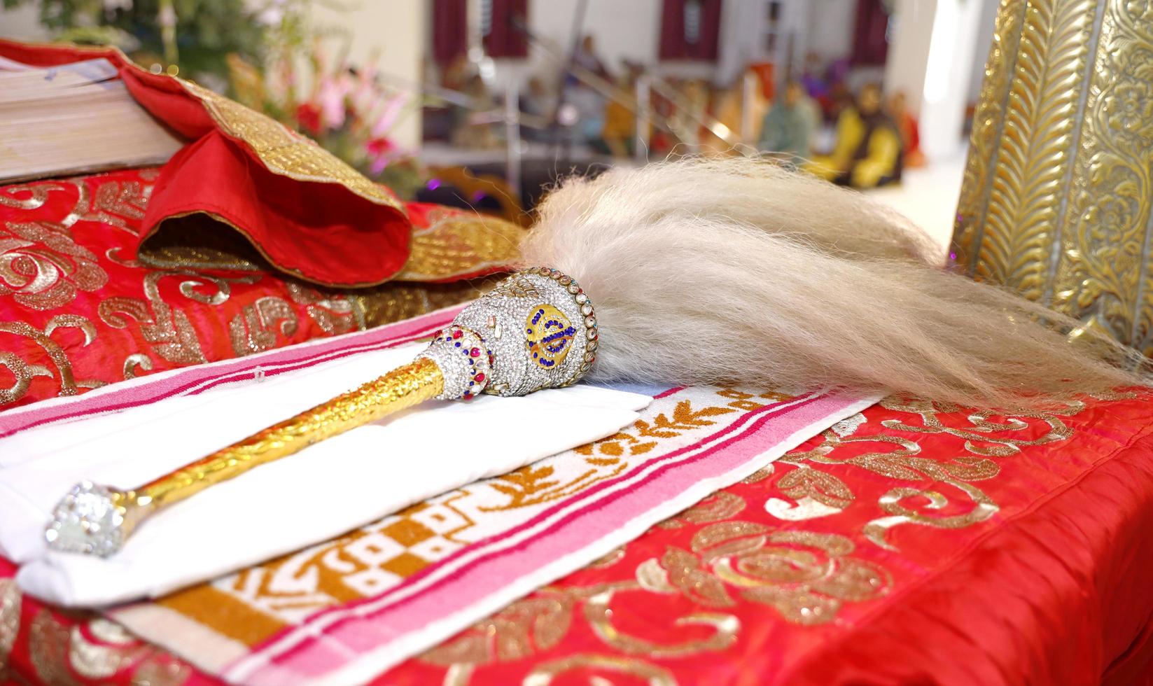 Fan to worship Guru Granth Sahib inside a Gurudwara with Golden handle and sikh symbol photo