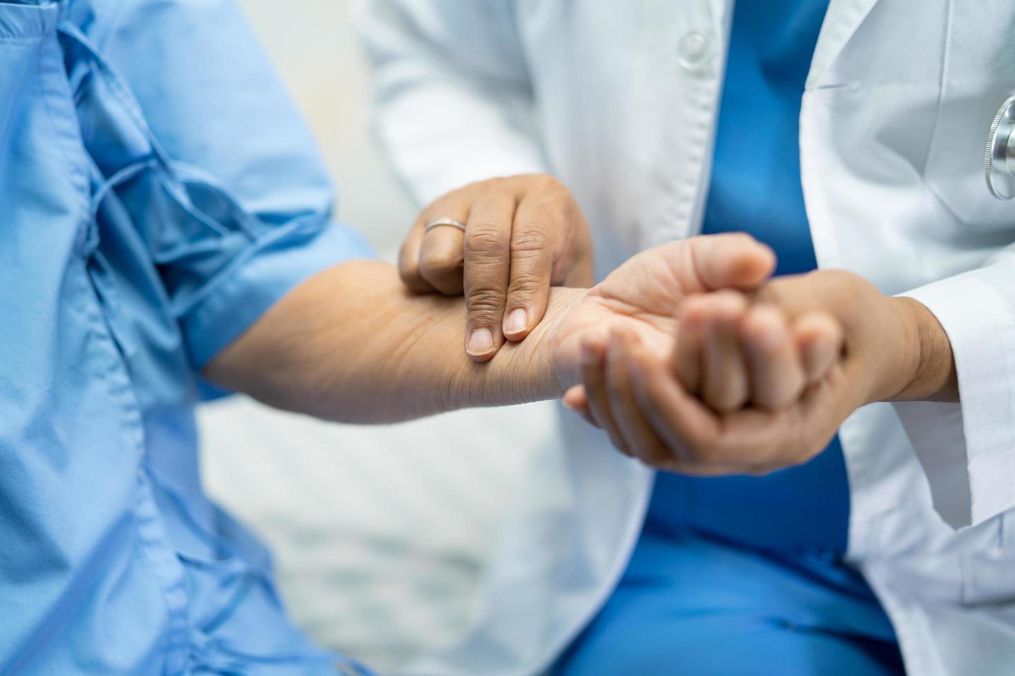 Doctor catch the pulse with patient in nursing hospital ward, healthy strong medical concept. photo