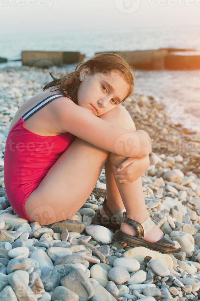 Portrait of a teenage girl on the seashore. A glance at the camera. Close-up photo