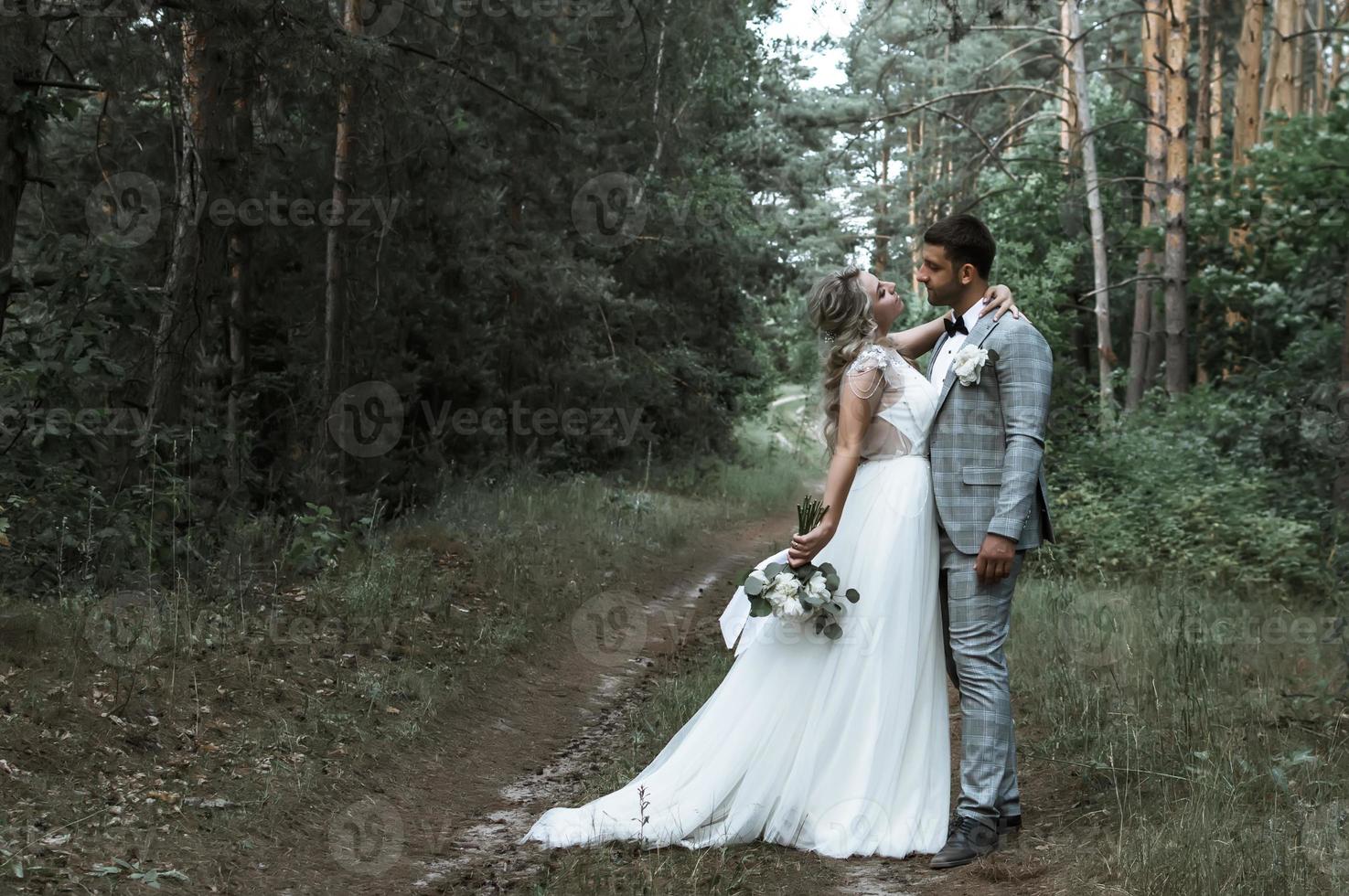 the bride and groom embrace in the forest on the wedding day. wedding ceremony. selective focus. film grain. photo