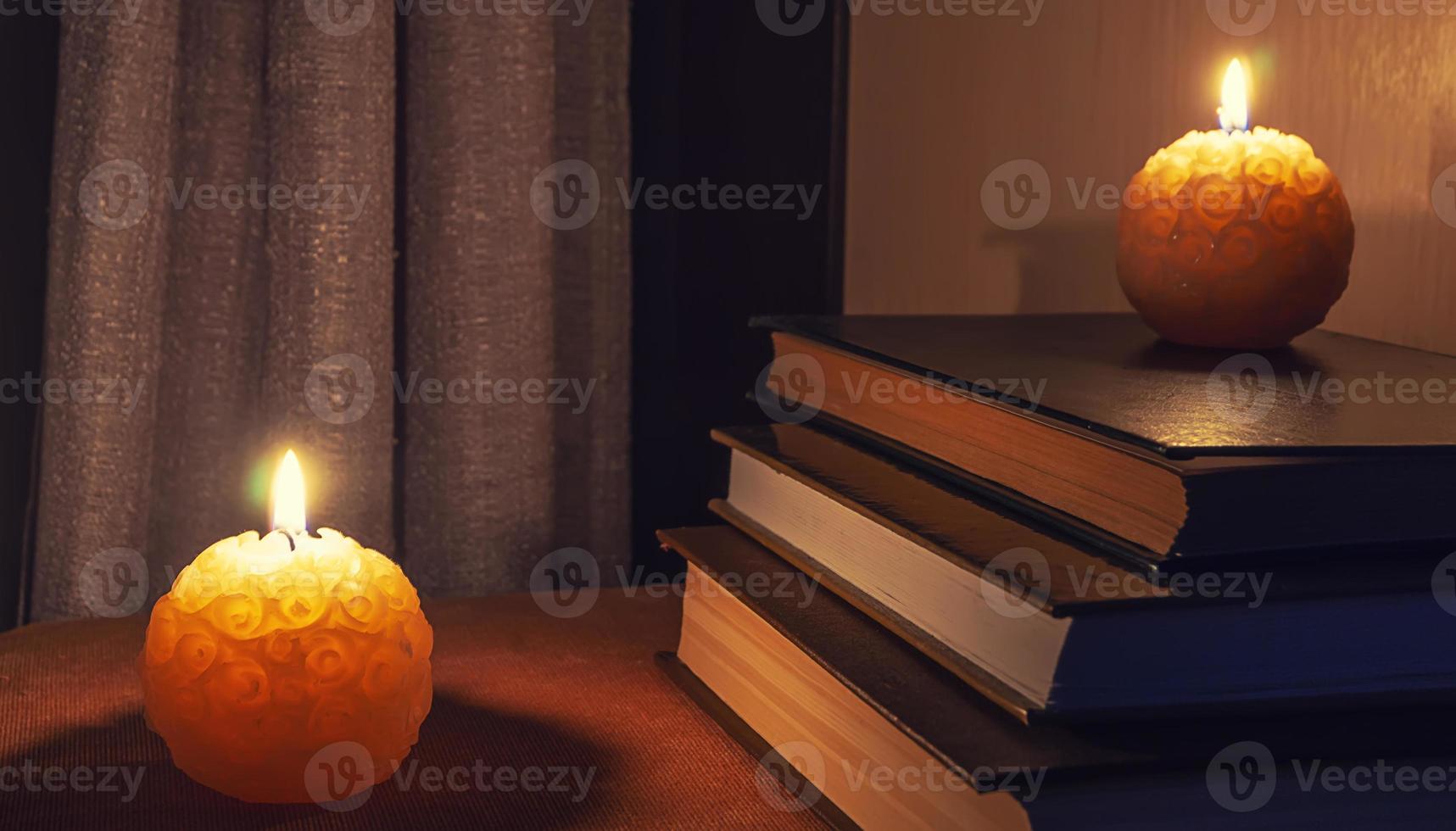libros sobre la mesa iluminados con luces nocturnas y velas foto