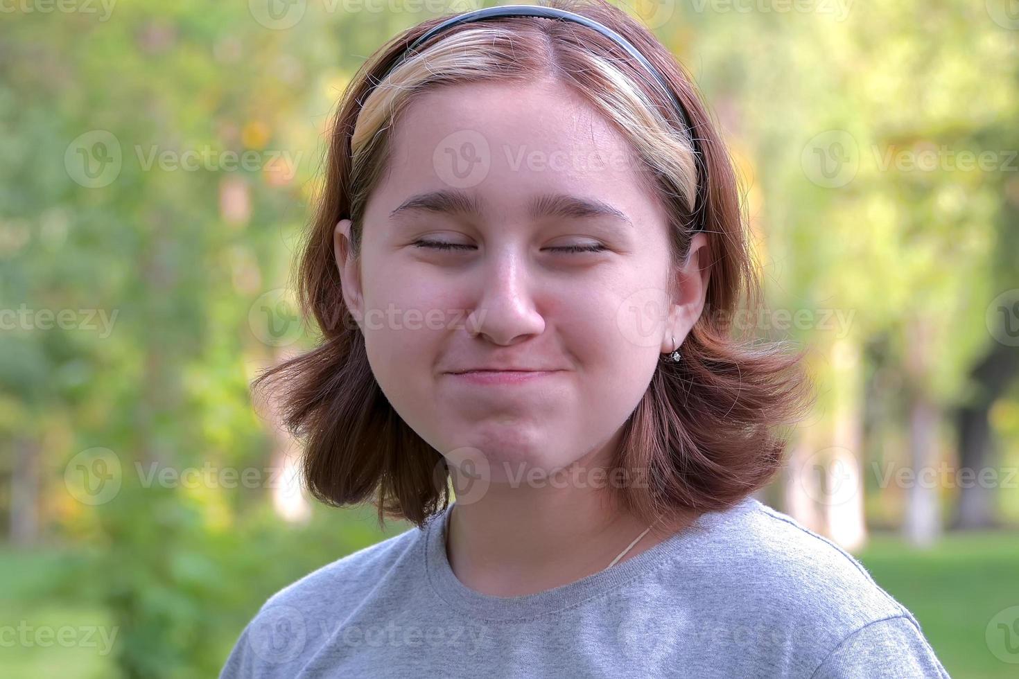 a teenage girl with an Asian appearance chews up leftovers and laughs with crumbs from her mouth photo