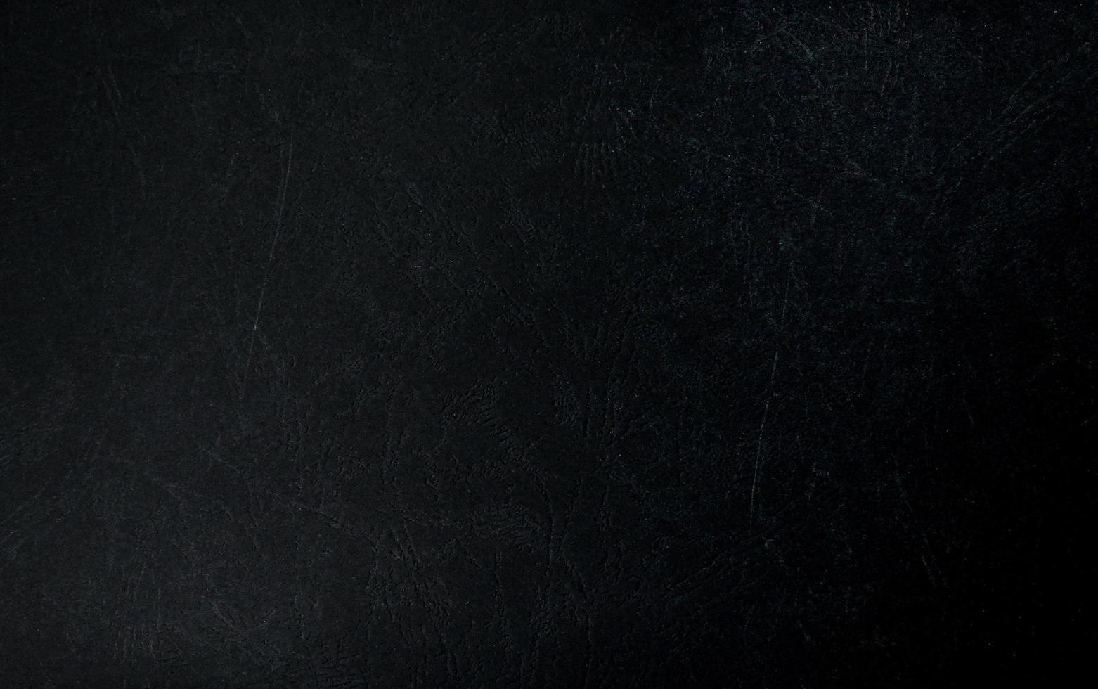 Black leather background. Dark textured close up on detailed grunge leather. Macro shot on luxury parchment surface. photo