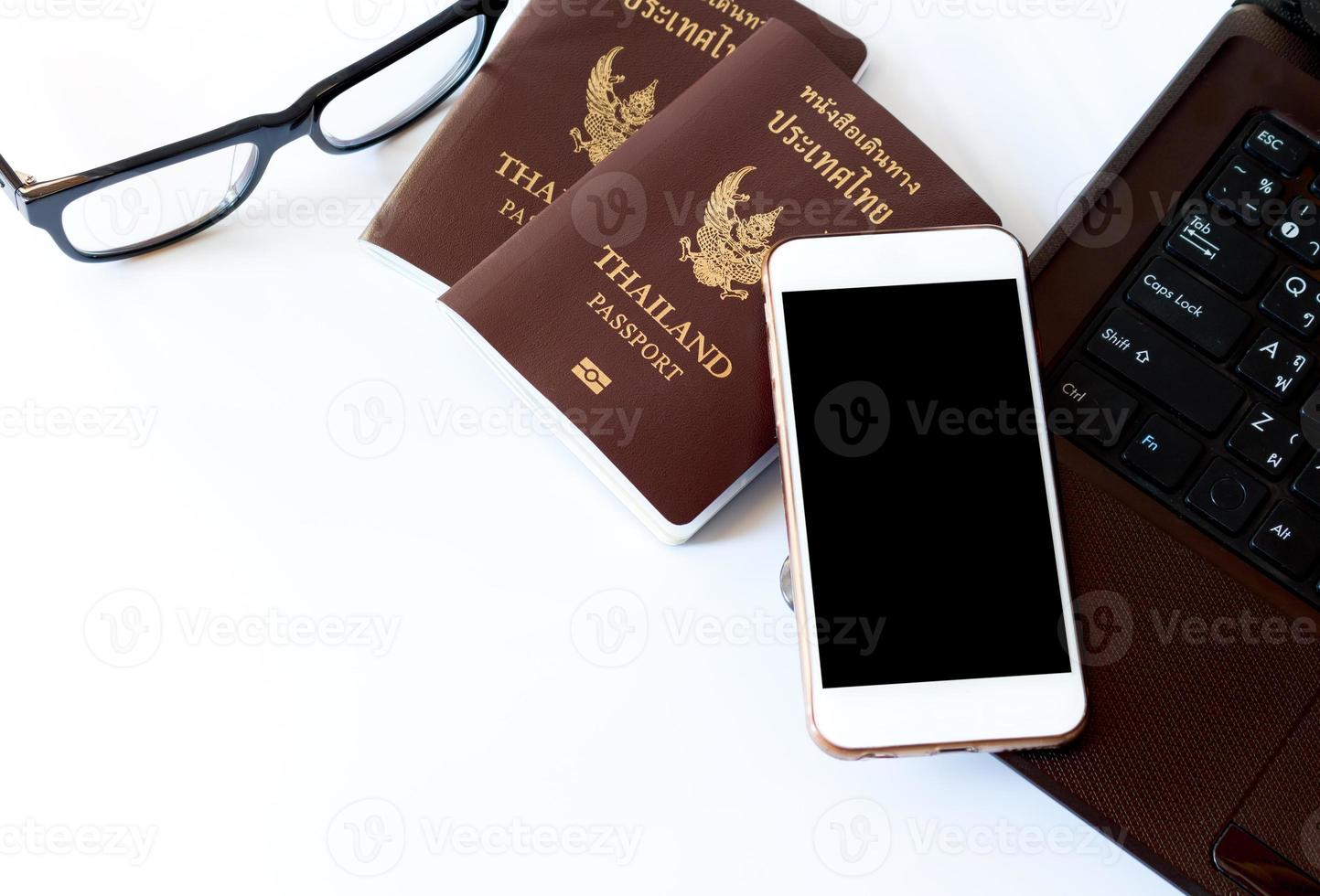 accesorios de viaje disfraces. pasaportes, preparación para viajar, teléfono inteligente, anteojos y laptop para vacaciones, enfoque suave. foto