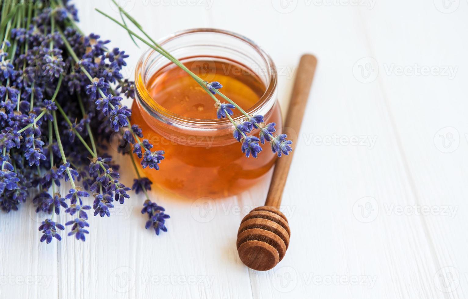 Jar with honey and fresh lavender flowers photo