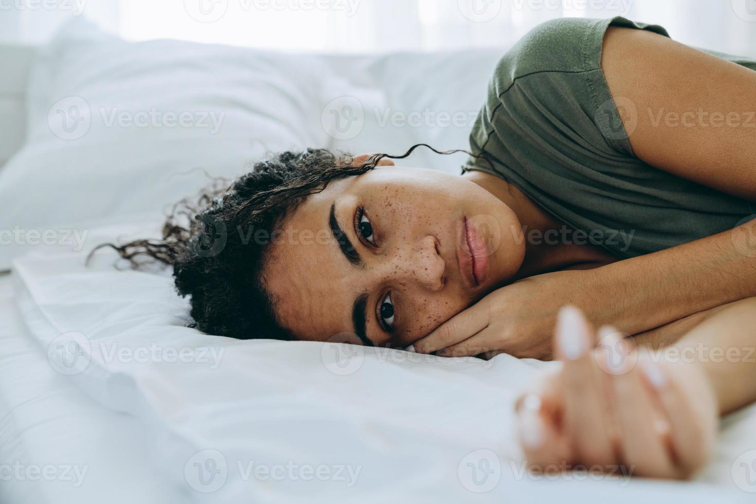 Portrait of African sad woman lying on bed photo