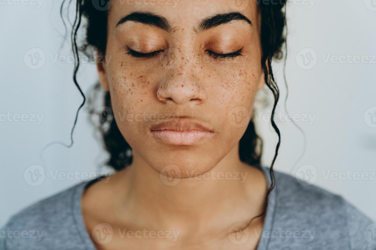 Black woman posing with eyes closed during spending time at home photo