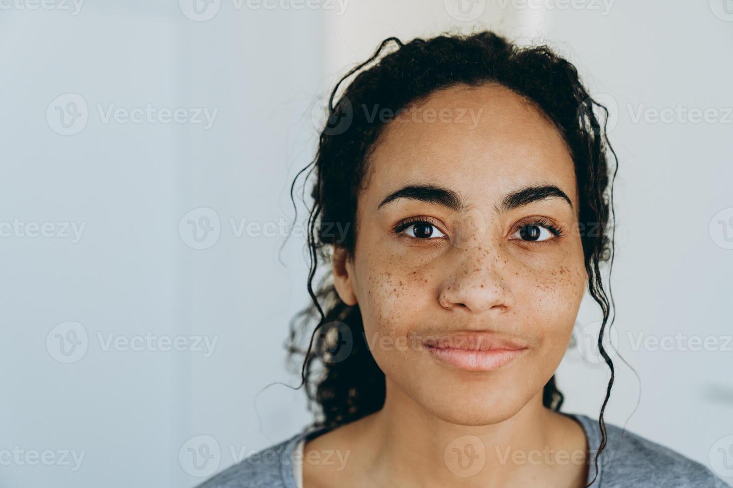 Black woman smiling and looking aside during spending time at home photo