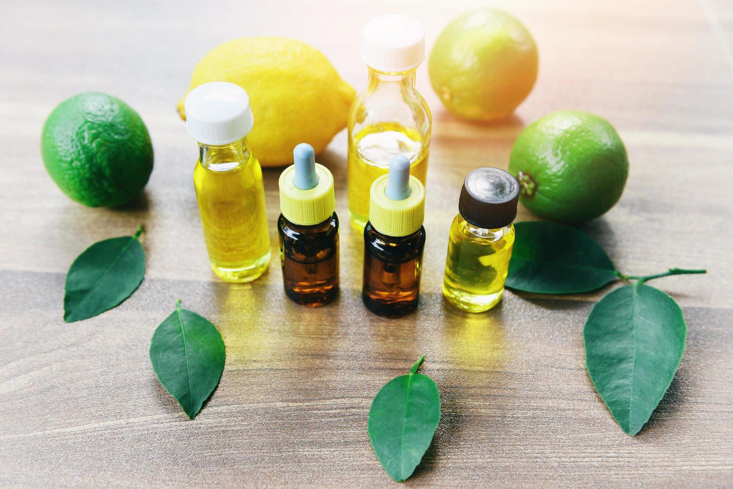Aromatherapy herbal oil bottles aroma with lemon and lime leaves herbal formulations - Essential oils natural and green leaf organic photo