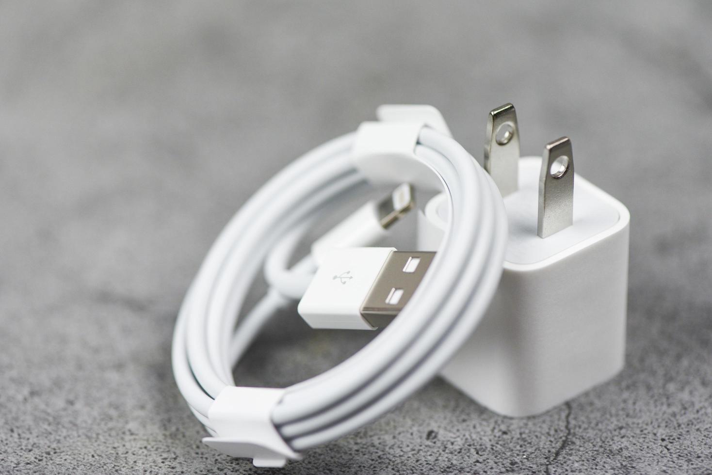 Adaptador eléctrico cable del cargador del puerto usb del teléfono inteligente sobre fondo gris - adaptador de cargador de teléfono móvil foto