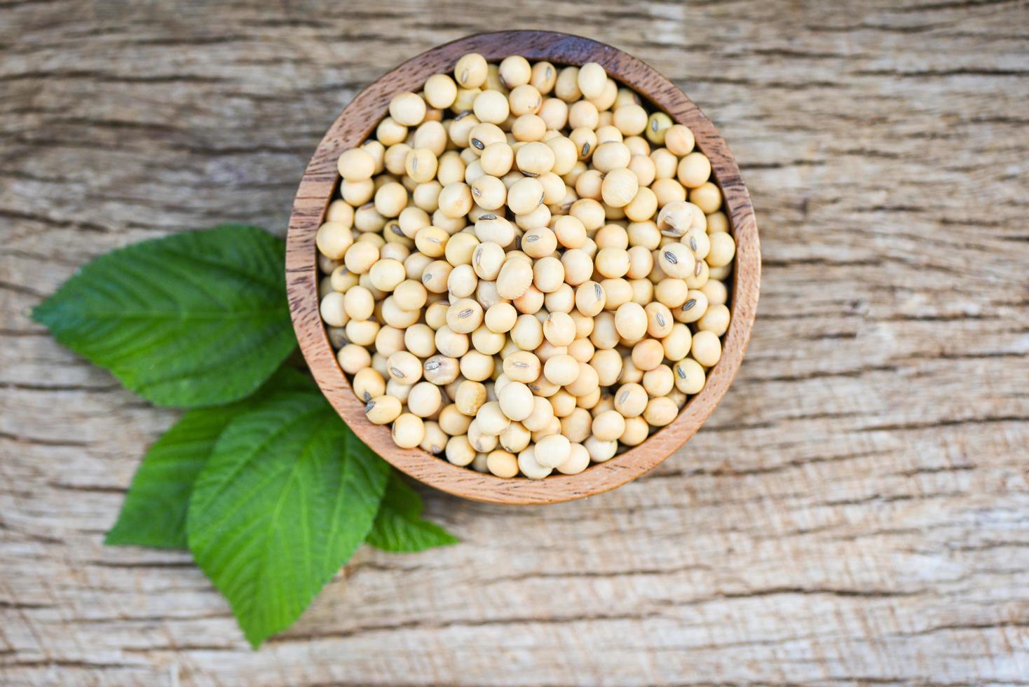 Soya , Soybean in a wooden bowl agricultural products on the wood background dry soy beans and green leaf photo