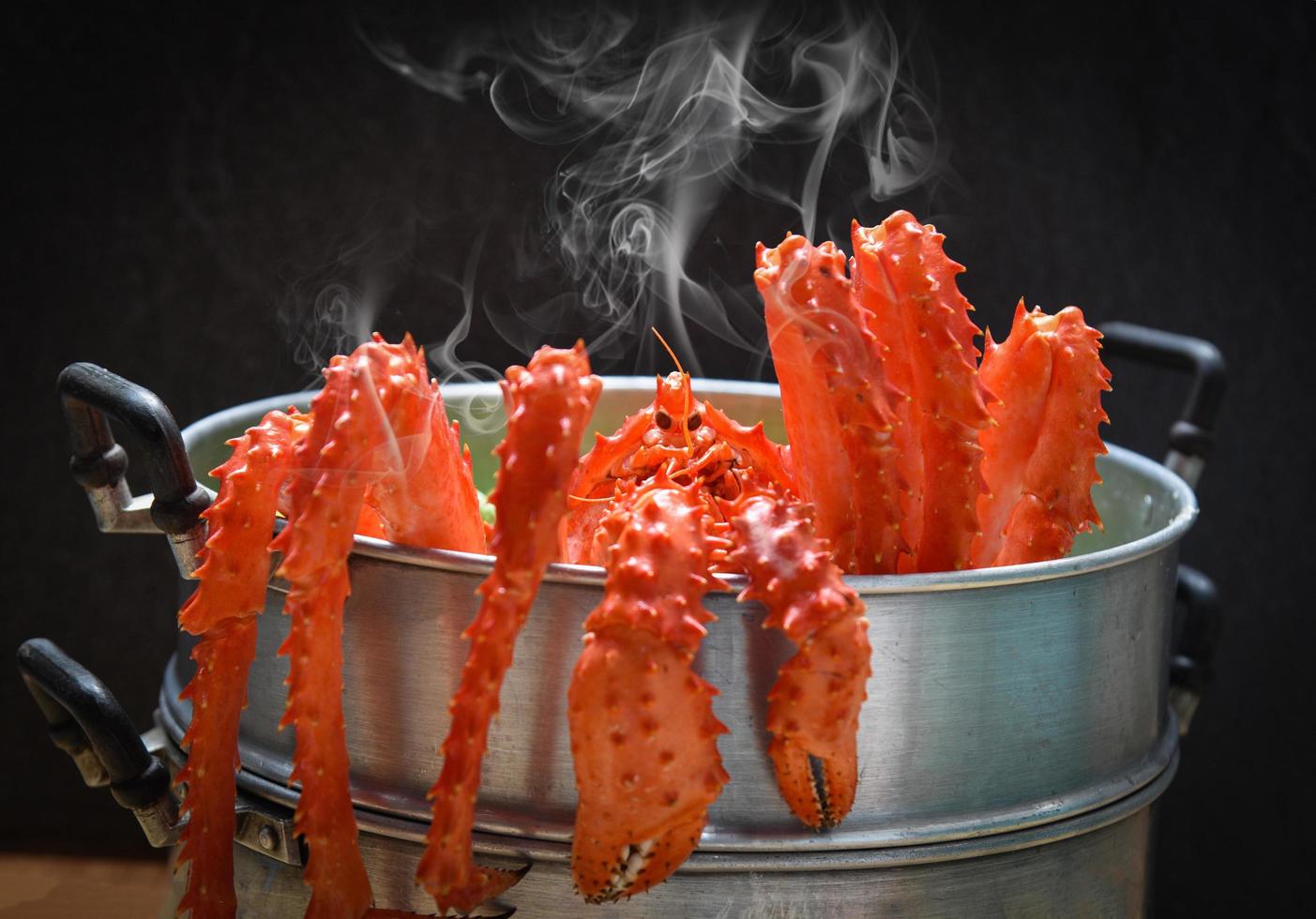 Alaskan King Crab Cooked steamer food on steaming pot seafood and lettuce vegetable with dark background - red crab hokkaido photo