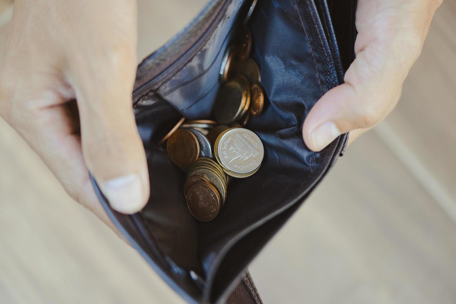 Coin in wallet and debt management concept - Empty wallet in the hands of an elderly man Poverty in retirement concept photo