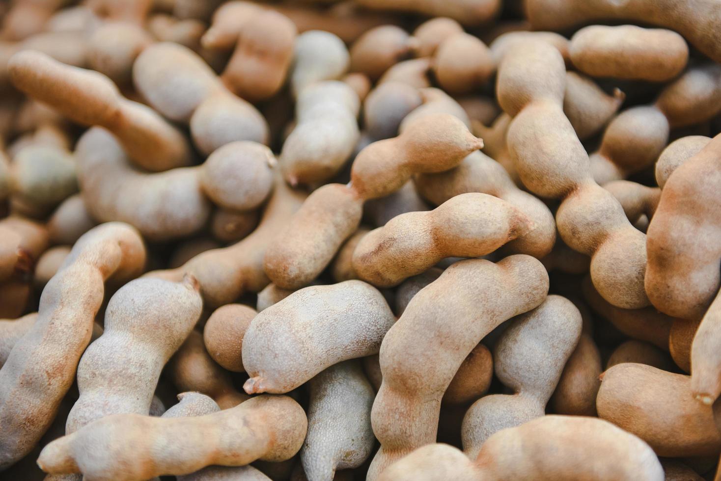 Montón de tamarindo dulce para la venta en el mercado de frutas - fondo de textura de tamarindo fresco foto