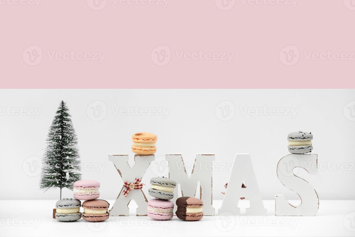 rench dessert macaroons or macarons on Christmas white and pink background with inscription xmas. food recipe concept. copy space. photo