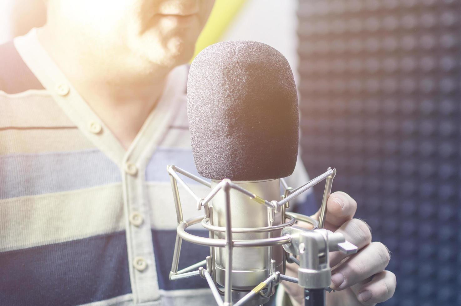 un hombre en un micrófono en un estudio de grabación. creatividad musical. foto