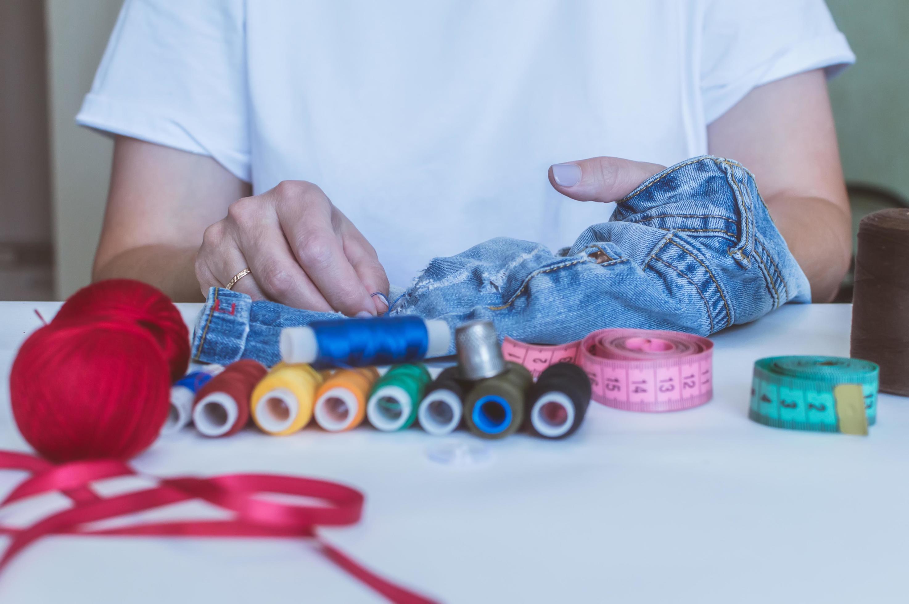 Female hands of designer at work with fabric close-up. Tailor