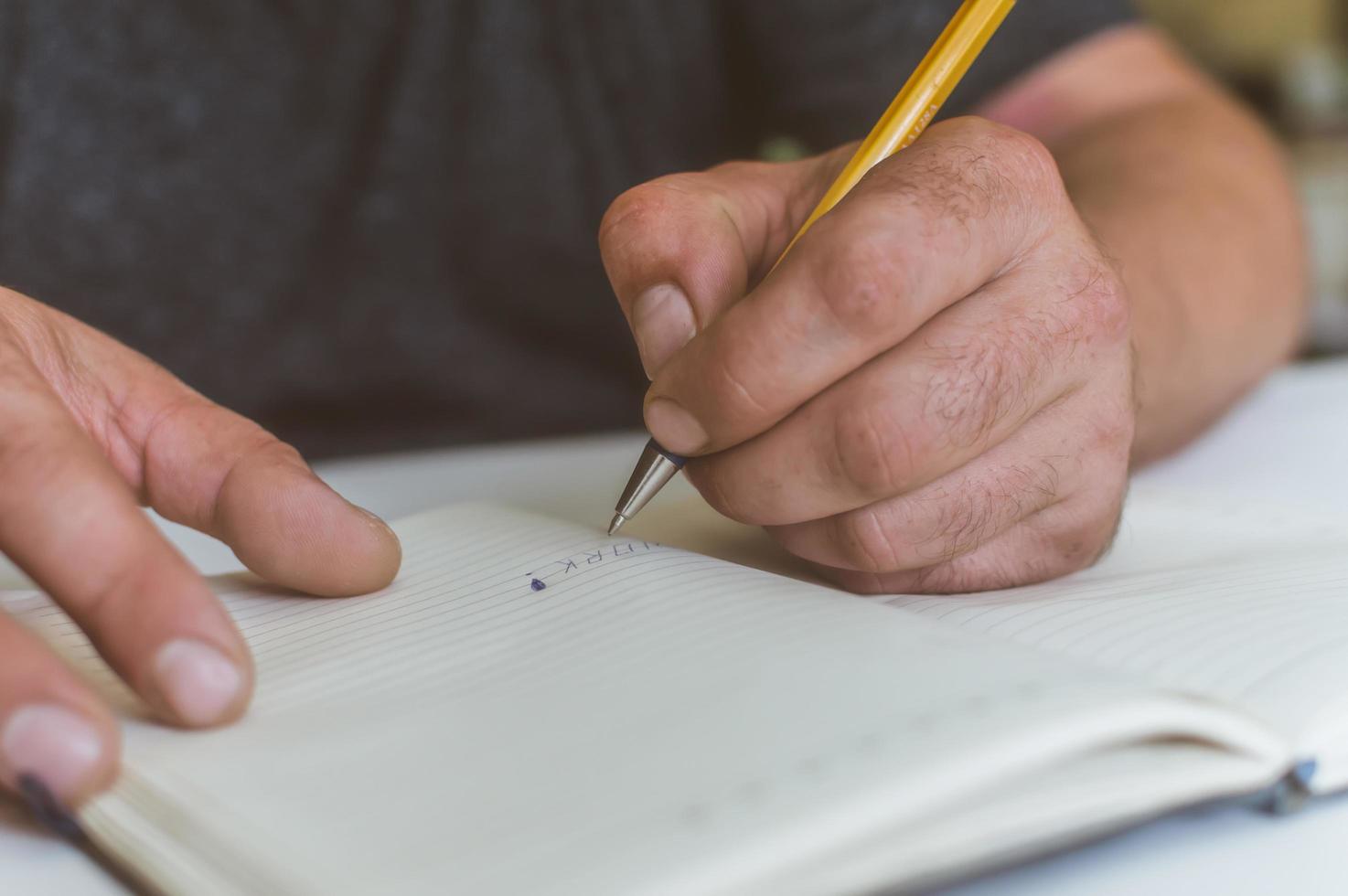 una persona hace una entrada en un cuaderno para hacer negocios foto