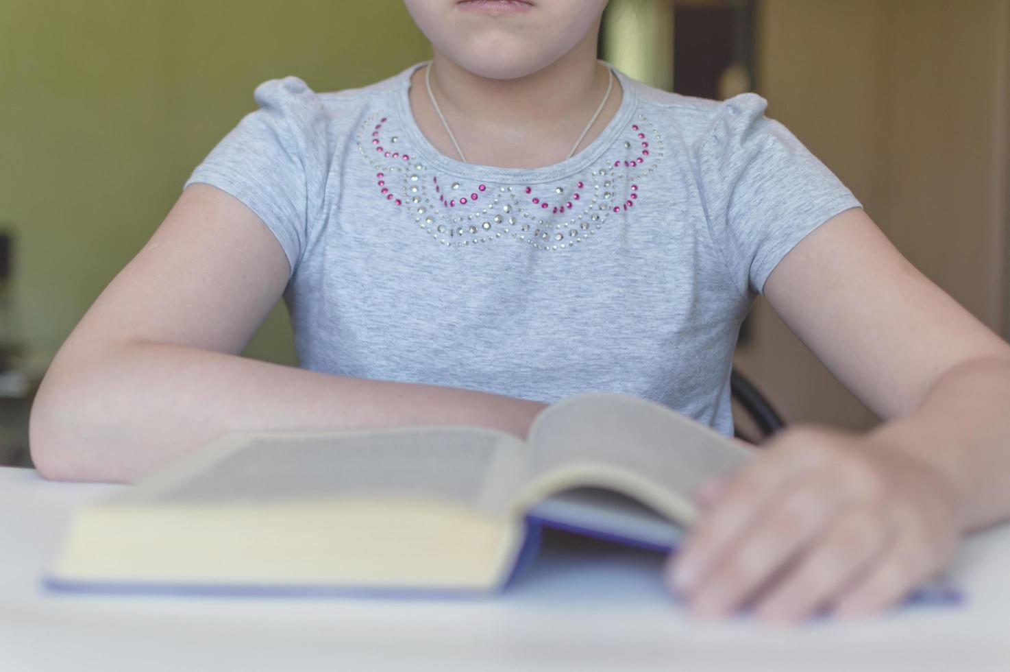 child reading a book at the table photo