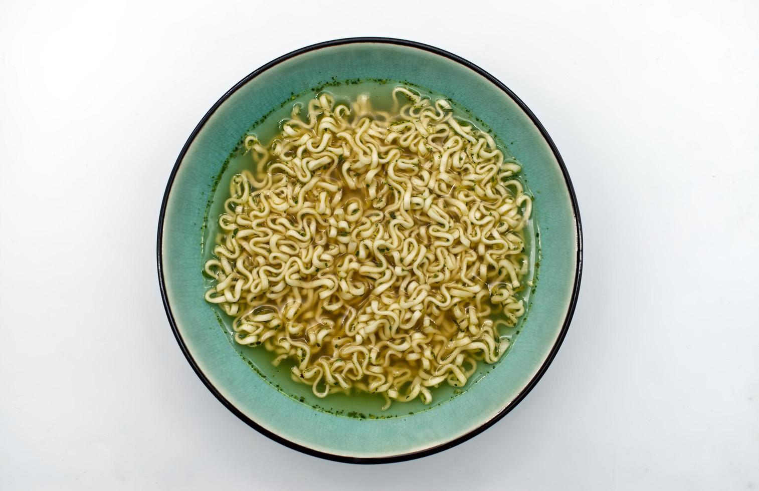 Chicken noodle cream soup in a bowl isolated on white background. Top view photo