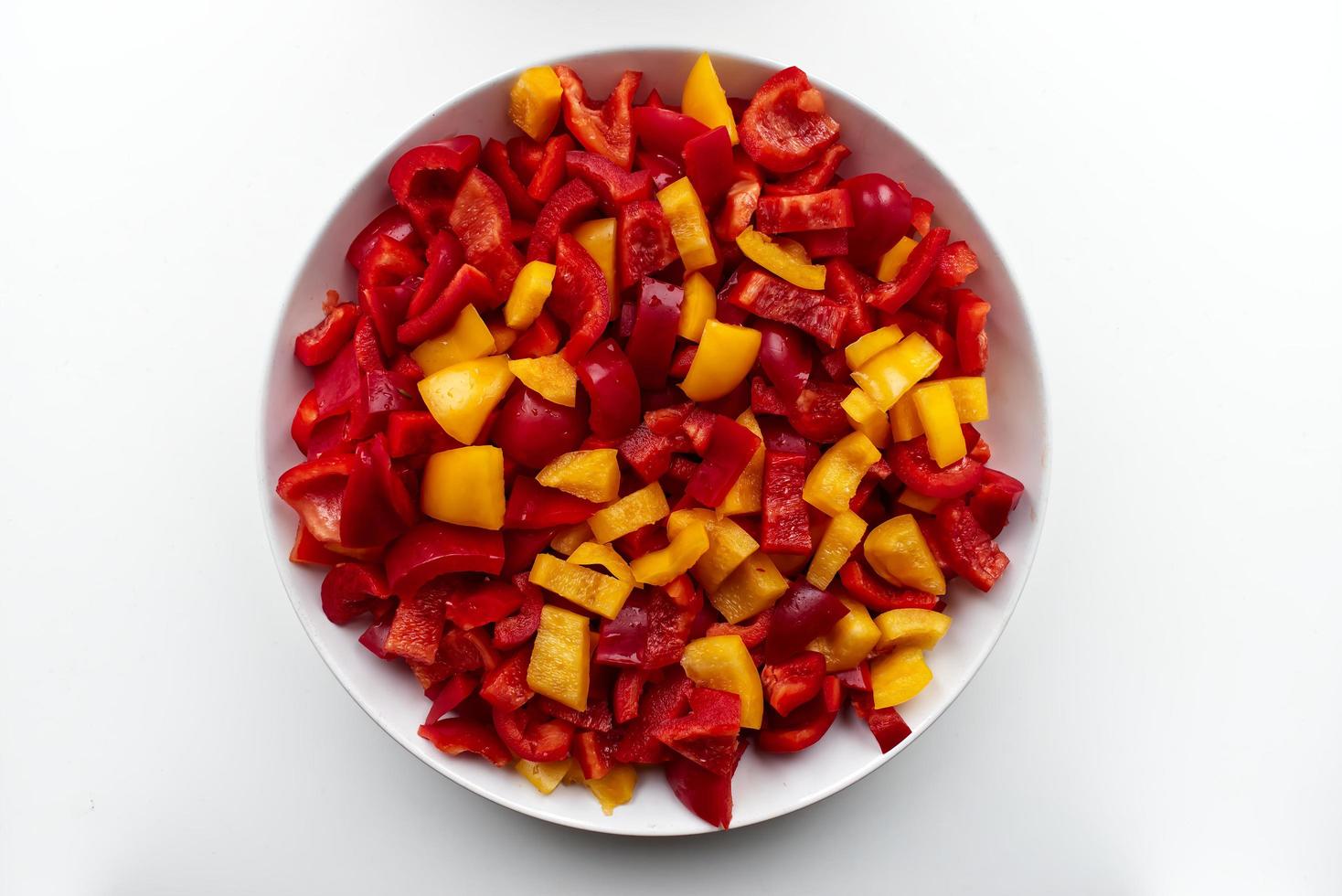 Fresh red and yellow sliced pepper on white background. View from above photo