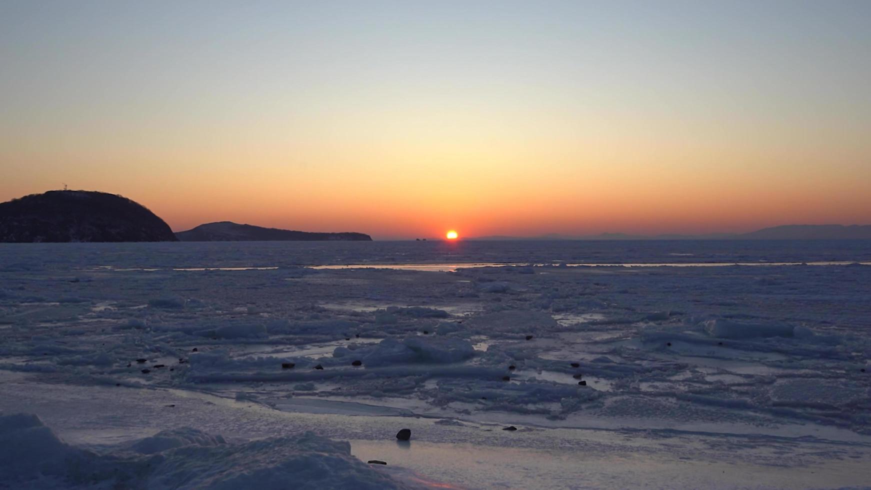 Landscape with a sunset over the icy surface of the sea. photo