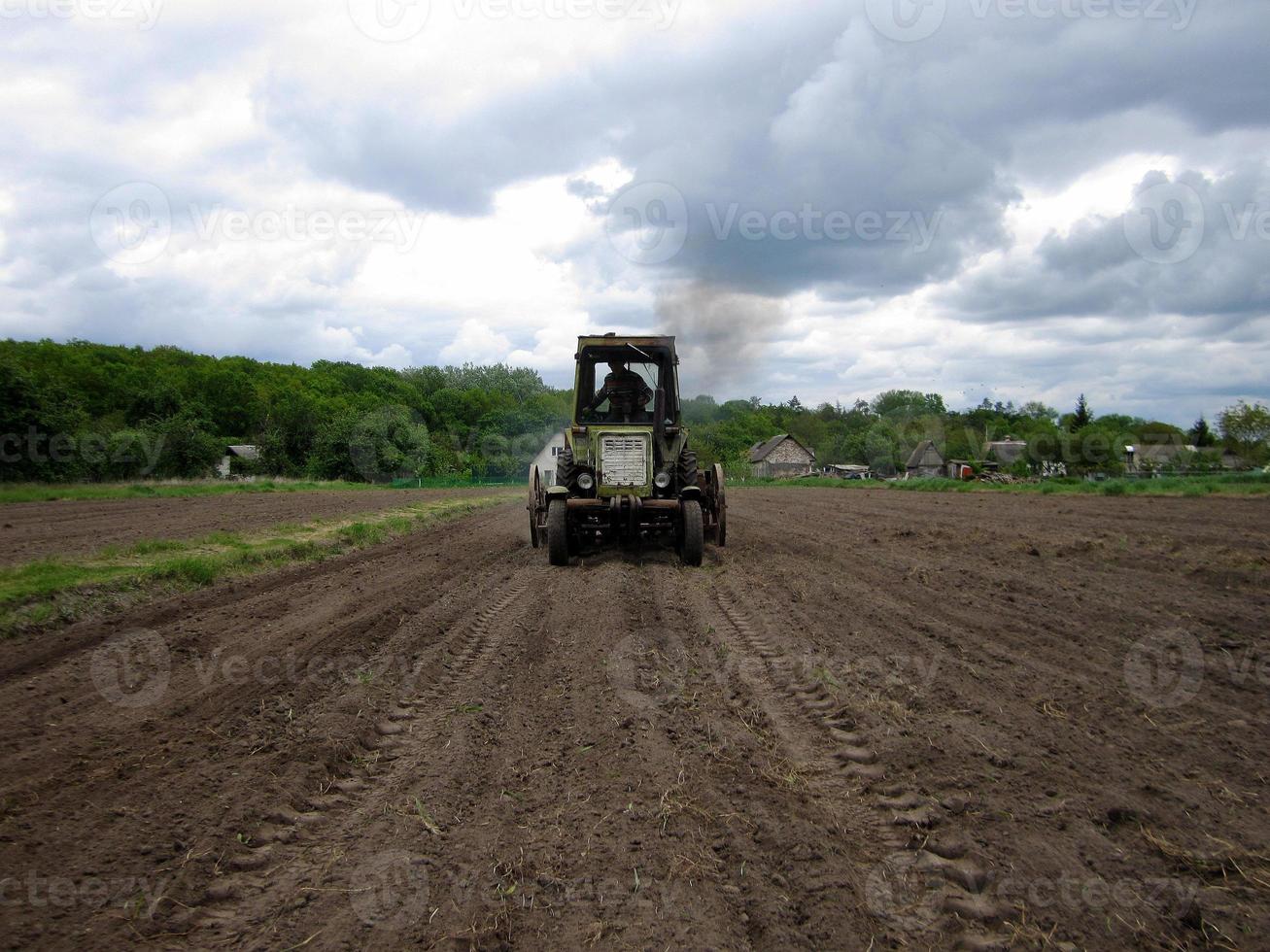 Plowed field by tractor in brown soil on open countryside nature photo