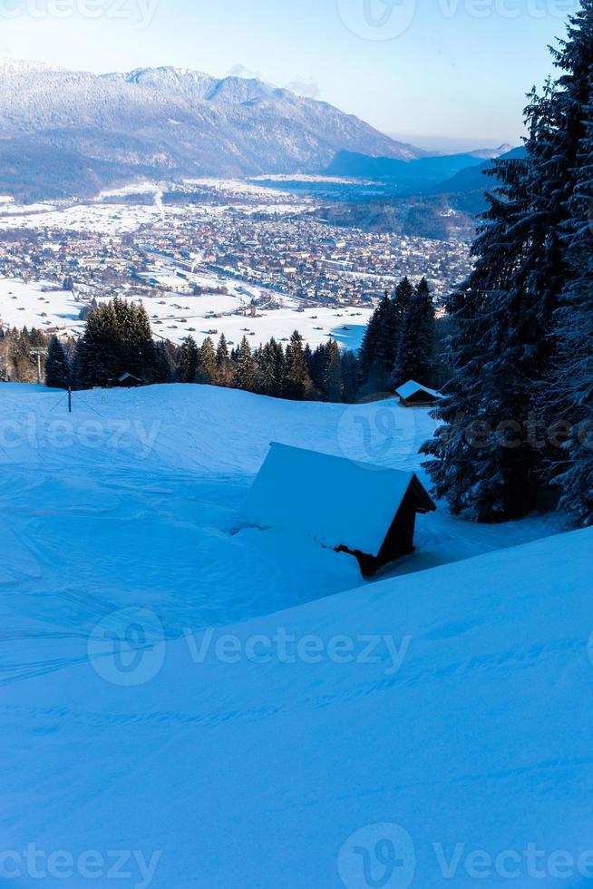 Cabaña en la ladera de la montaña cubierta de nieve con vistas garmisch partenkirchen foto