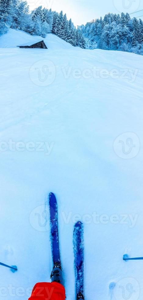 Esquiador subiendo hacia la cabaña de montaña foto