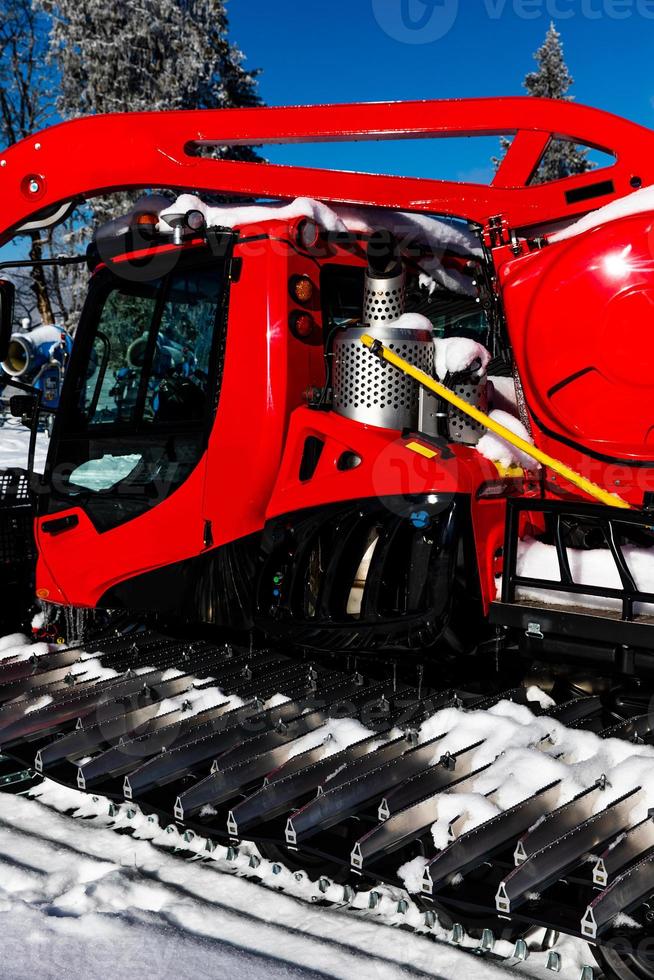 Red tractor with snow covered tracks photo