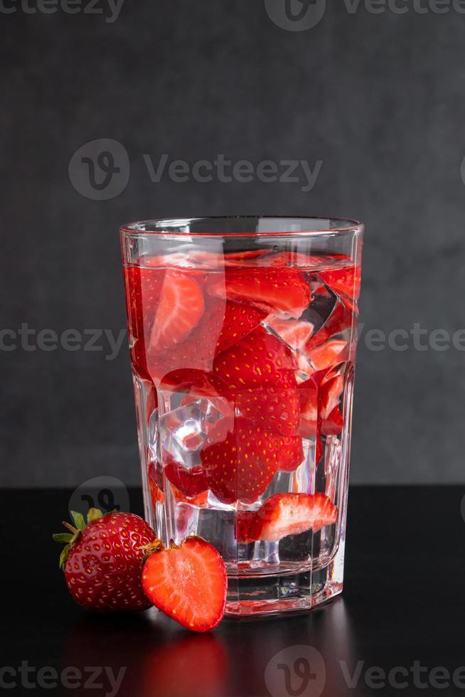 Cold drink with strawberries on black background. photo