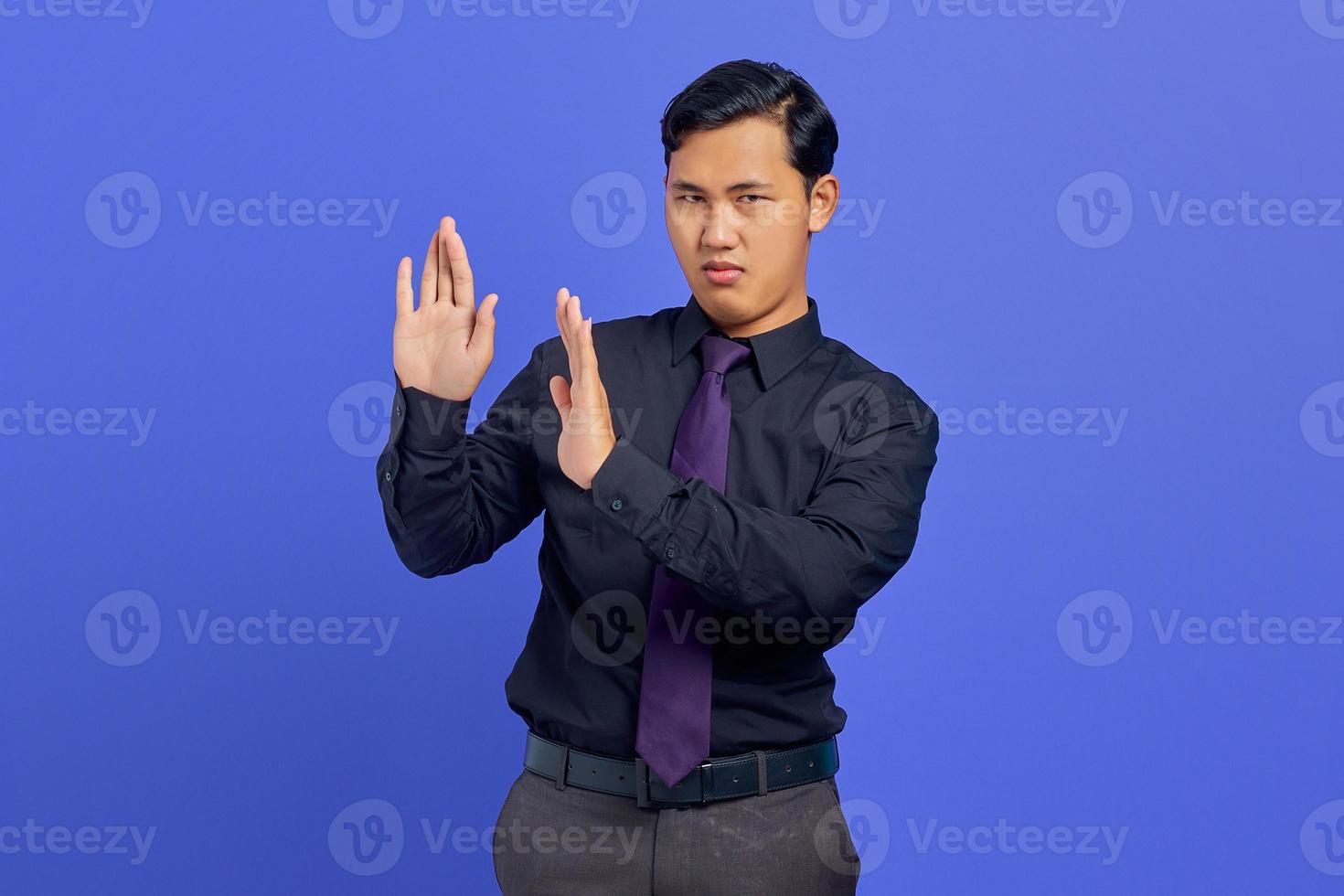 Foto del joven empresario haciendo stop motion con palm aislado sobre fondo púrpura