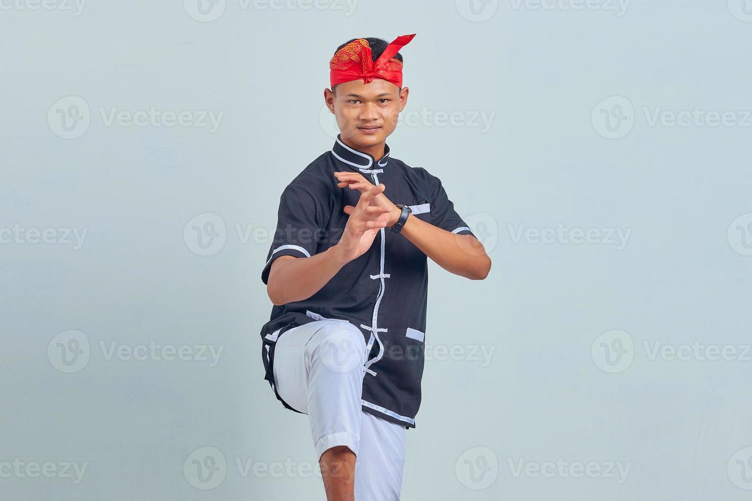 Picture of young sportsman dressed in kimono practice in karate isolated over grey background. looking at camera photo