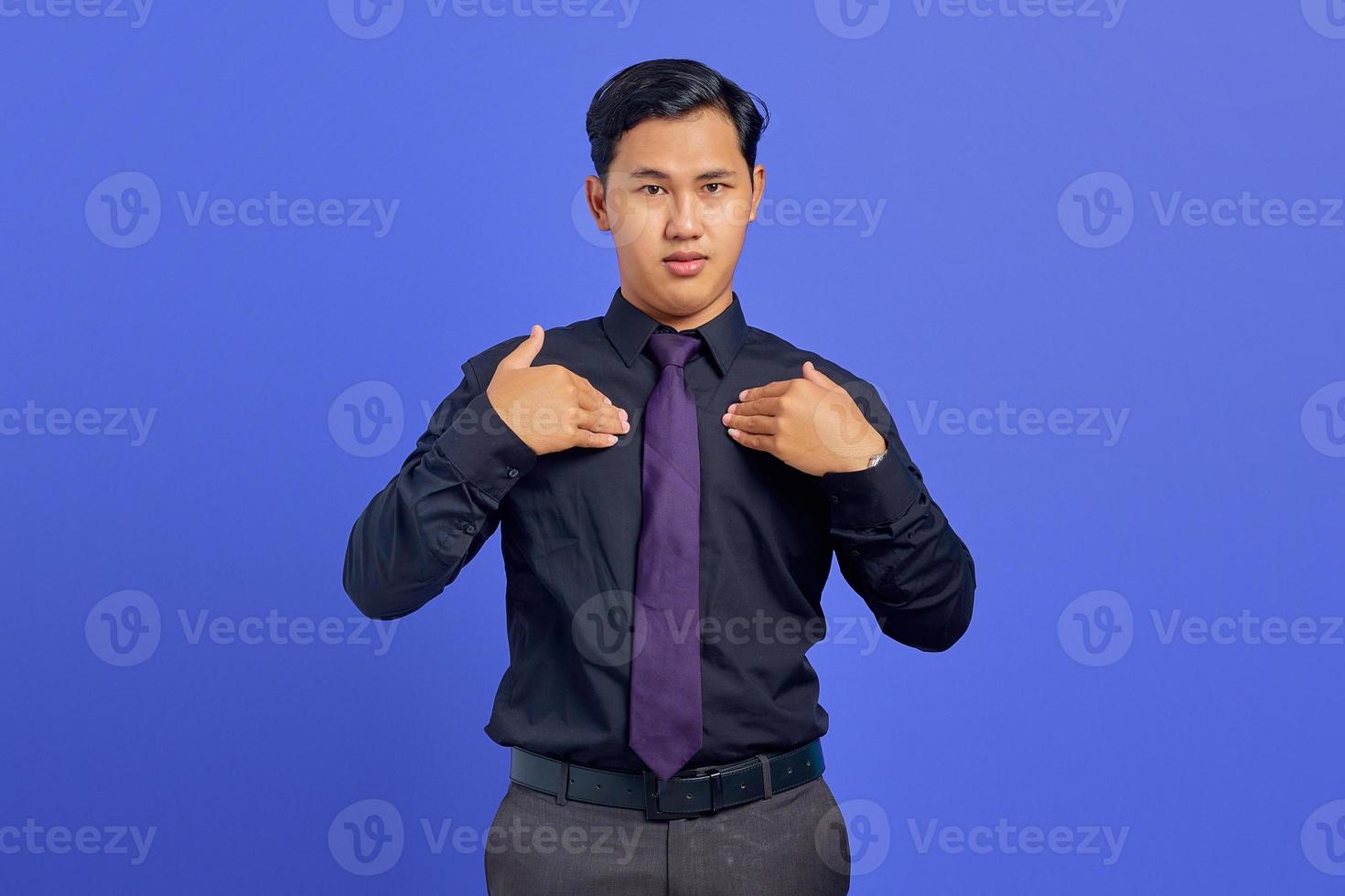 Confused young asian man pointing at herself on purple background photo