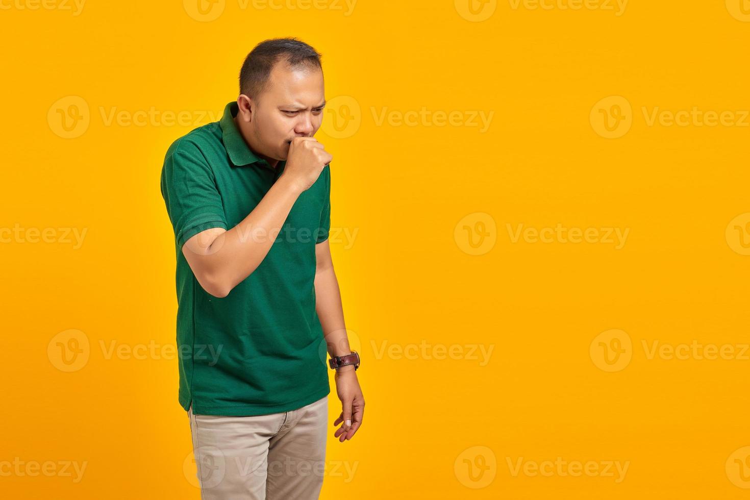 Portrait of Handsome Man feeling unwell and coughing on yellow background photo