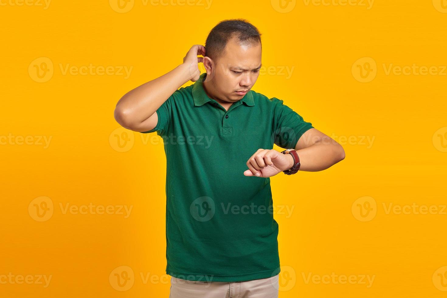 Portrait of young Asian man worried work deadline stress on yellow background photo