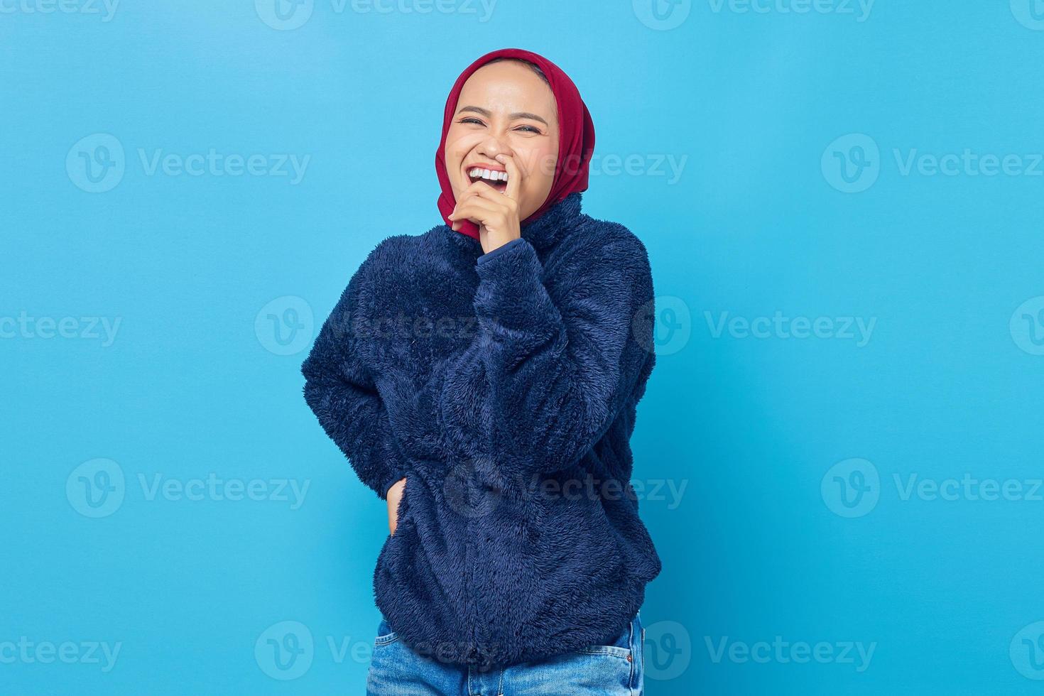 Portrait of cheerful young Asian woman looking sideways and pick your nose photo