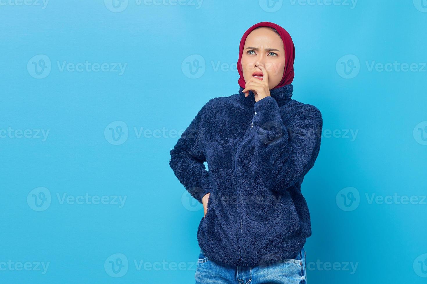 Retrato de mujer asiática joven seria mirando hacia los lados y recoger su nariz foto