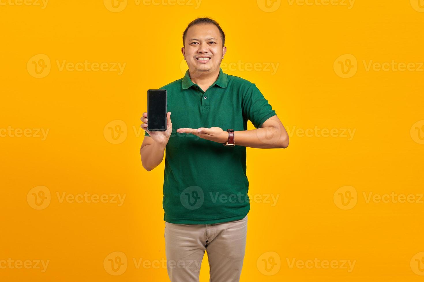 Cheerful handsome Asian man showing blank smartphone screen with palm. product promotion concept photo