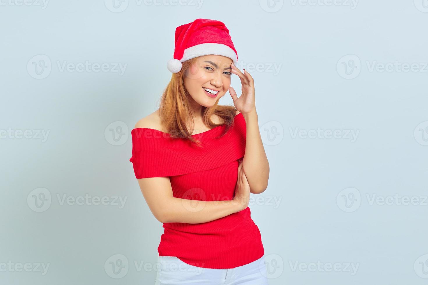 Retrato de hermosa mujer asiática vistiendo traje de Navidad pensando en algo con el dedo en la cabeza sobre fondo blanco. foto