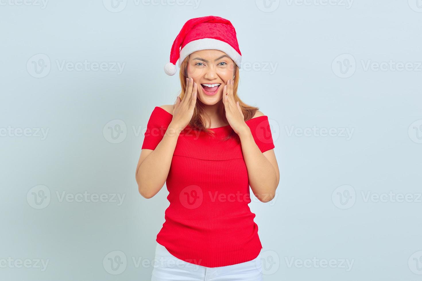 hermosa mujer joven con pelo corto con sombrero de navidad sorprendido con la boca abierta. concepto de navidad foto