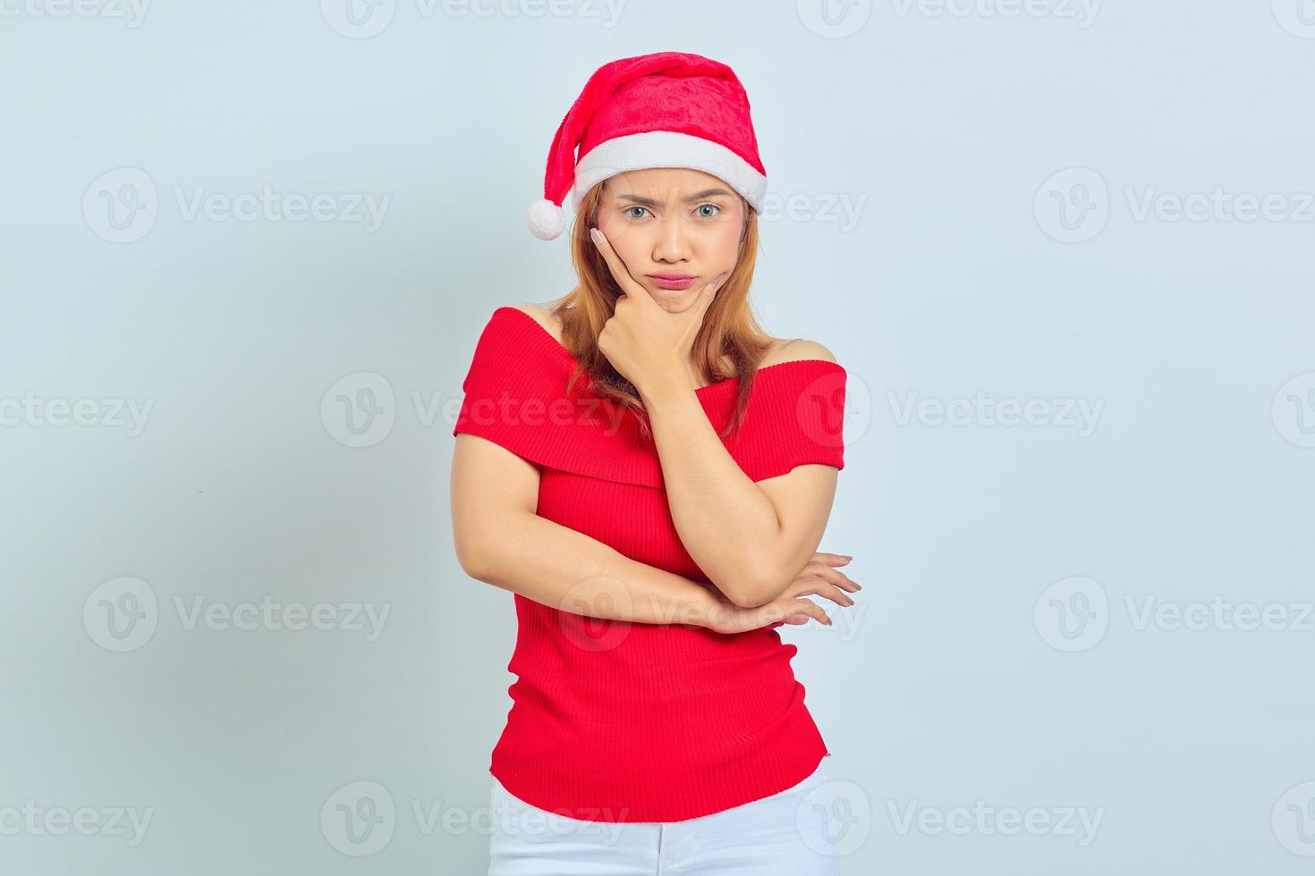 retrato, de, joven, mujer asiática, llevando, pensativo, vestido de navidad, pensamiento, pregunta, con, dedo, mentón, encima, fondo blanco foto