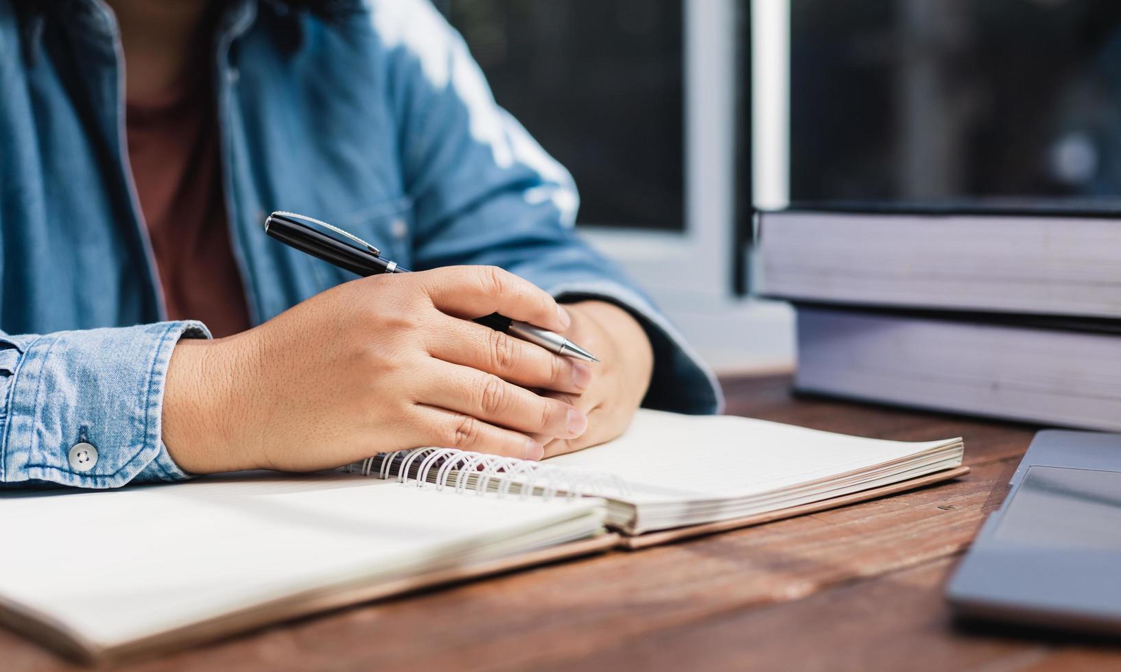 woman holding a pen sitting on a desk writing photo