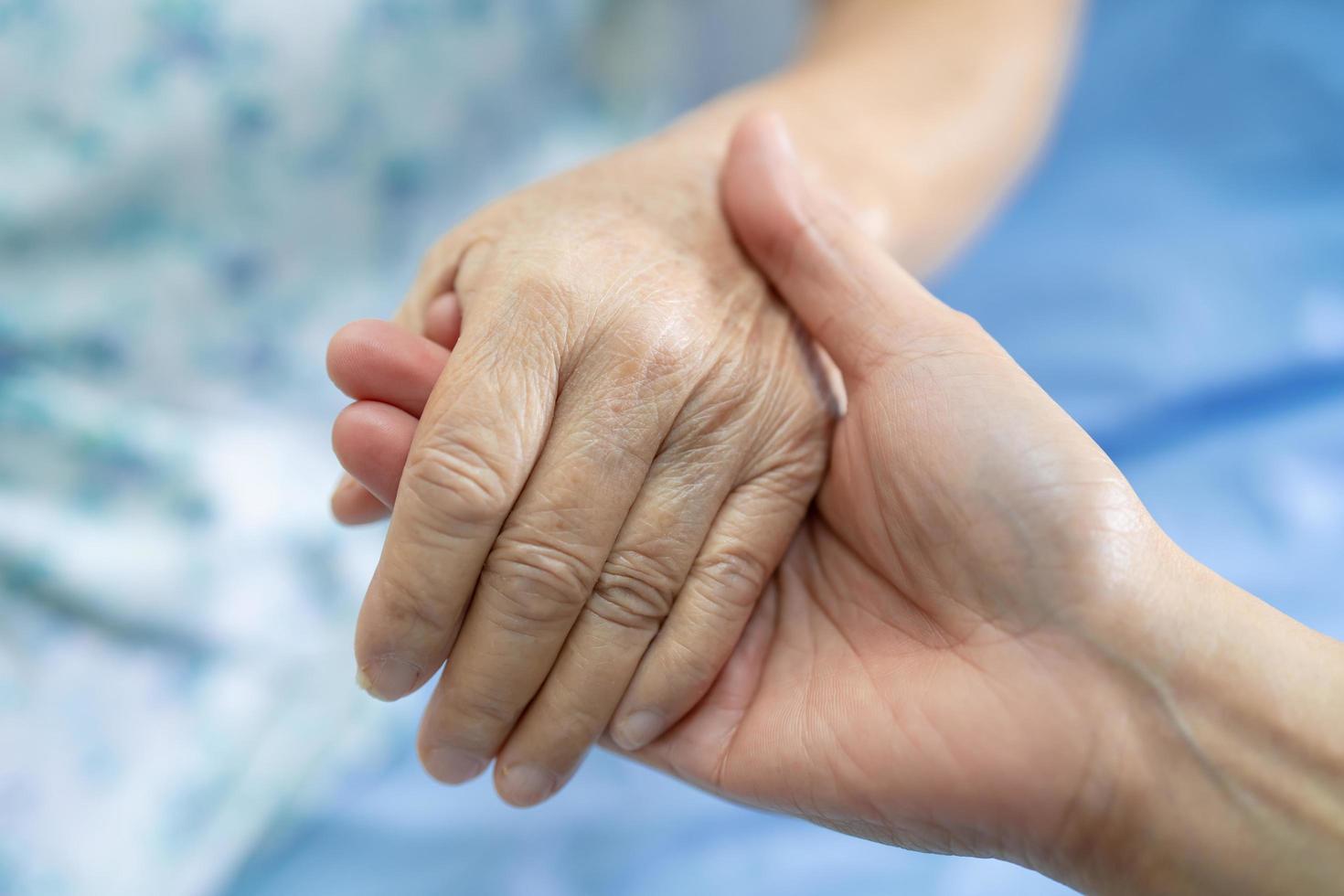 Tomados de la mano anciana asiática o anciana paciente con amor, cuidado, ánimo y empatía en la sala del hospital de enfermería, concepto médico fuerte y saludable foto