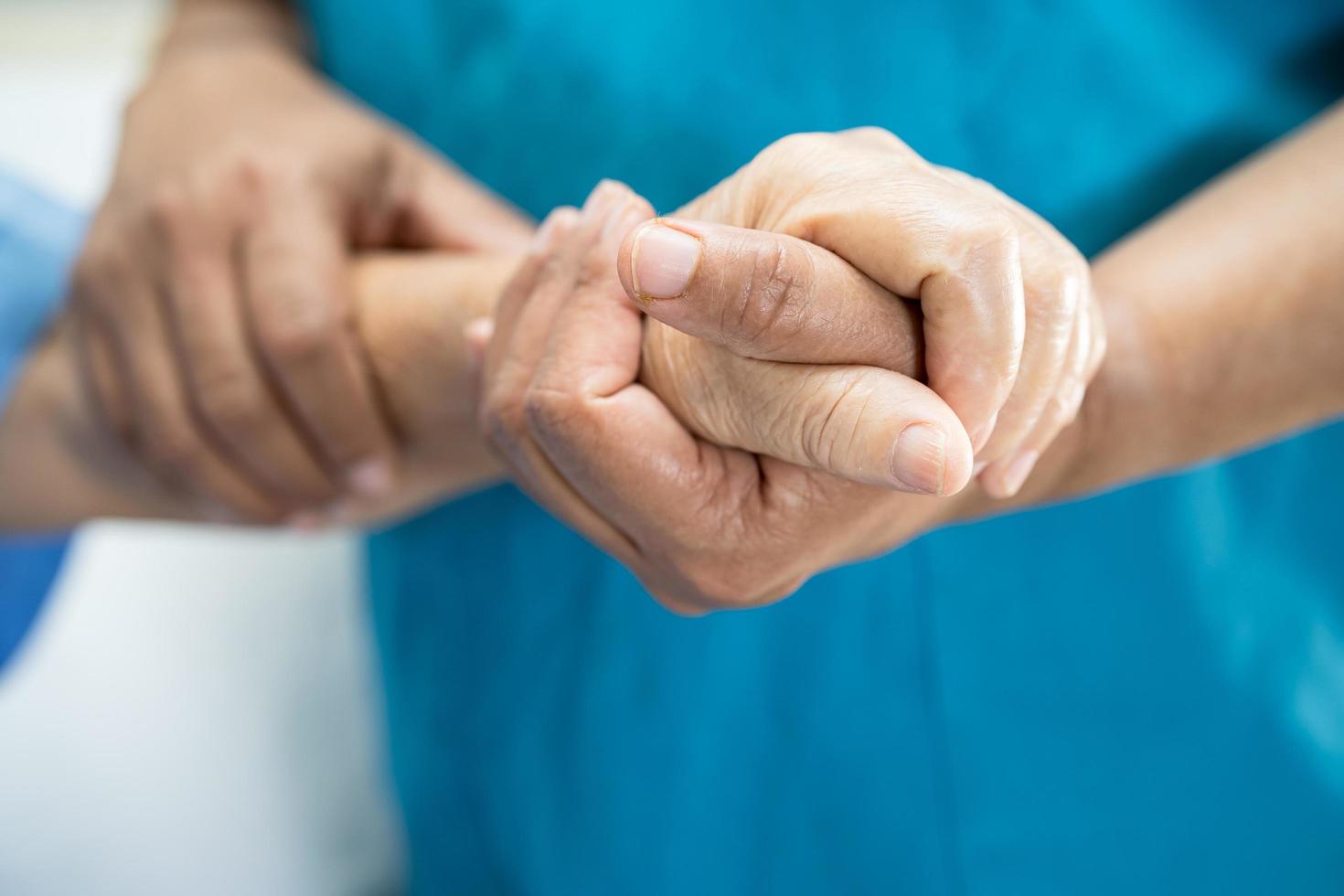 médico sosteniendo las manos conmovedoras anciana asiática o anciana paciente con amor, cuidado, ayuda, aliento y empatía en la sala del hospital de enfermería, concepto médico saludable foto