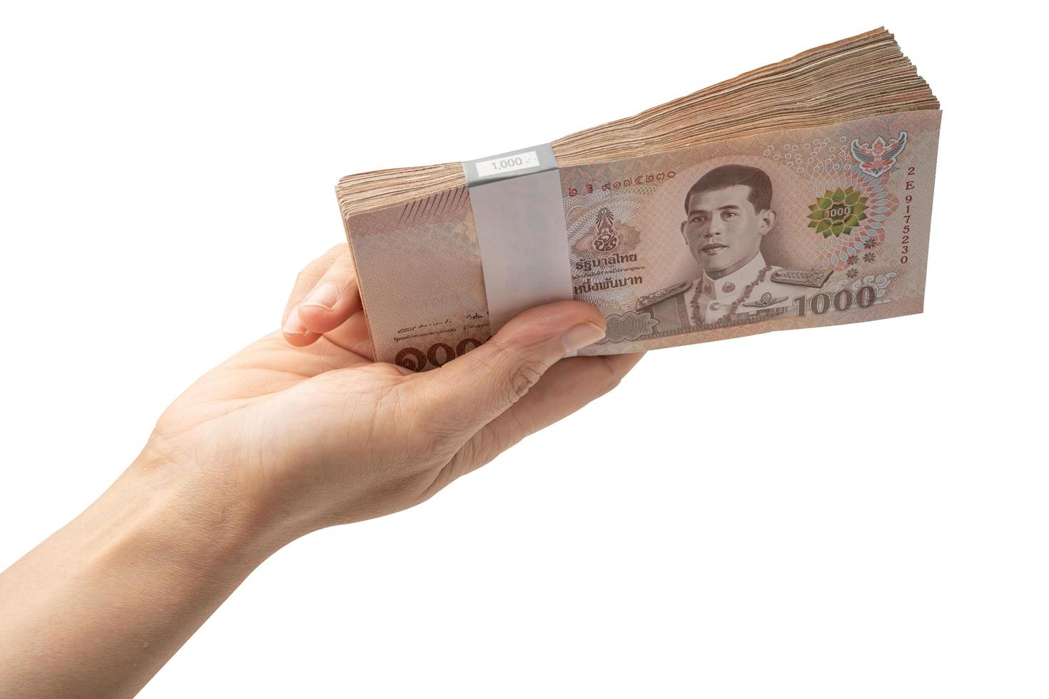 Holding stack of Thai baht banknotes on white background with clipping path  business saving finance investment concept. photo