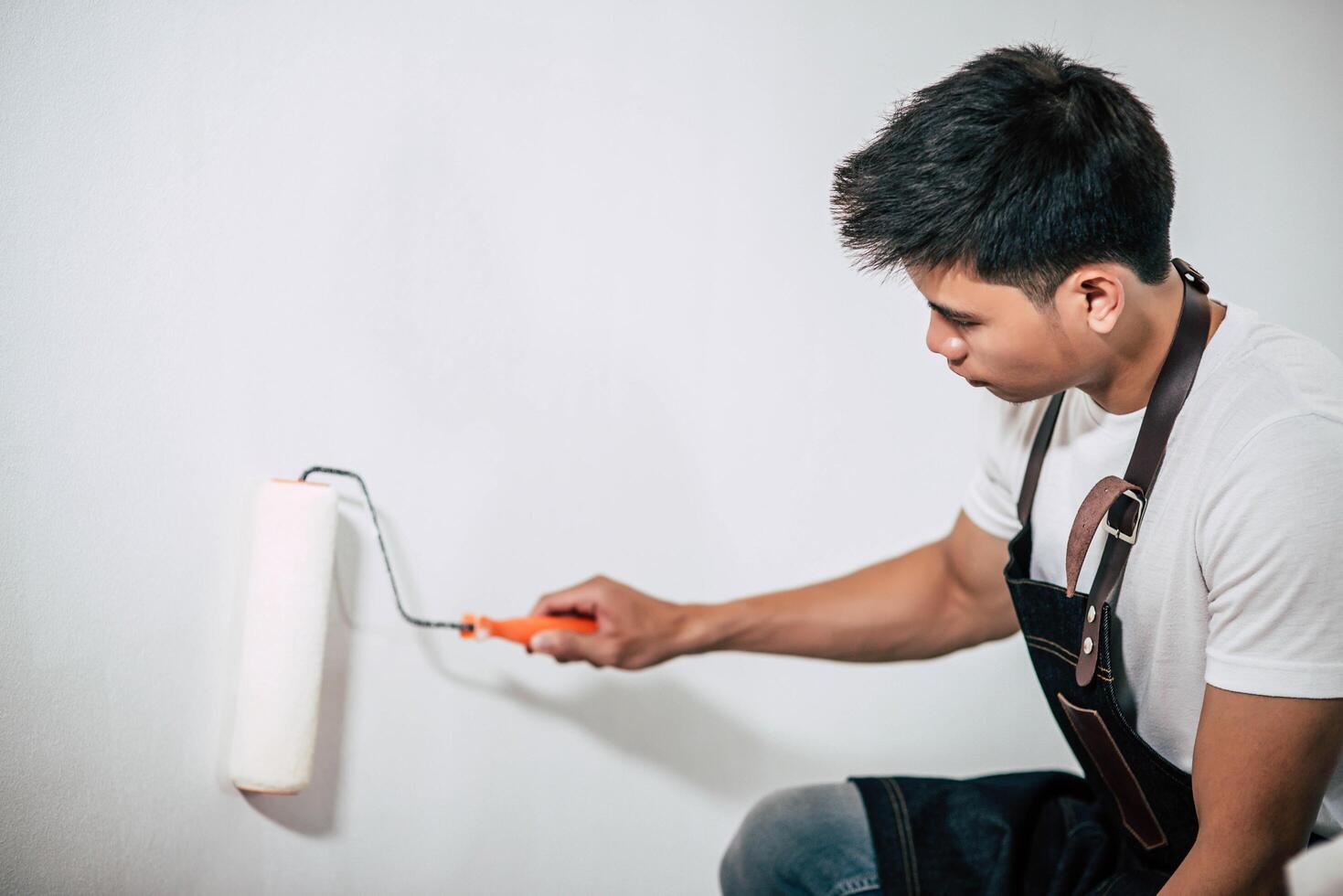 A carpenter holds a paintbrush and paints wood. photo